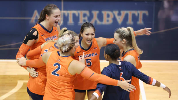 The Virginia volleyball team celebrates after scoring a point during a match against Rider at Memorial Gymnasium.